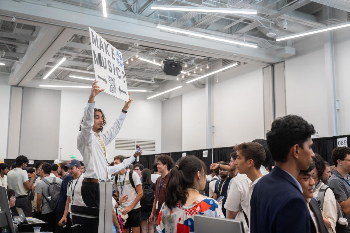 man standing on chair holding a sign